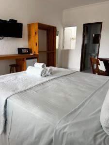 a bed with two towels on top of it at Suítes Cantinho do Ze em Milagres in São Miguel dos Milagres +28 photos