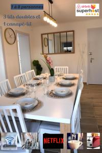 a white dining room table with white chairs and a white table and chairsktop at Le Nid des Cigognes avec terrace in Thionville