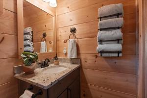 a bathroom with a sink and a mirror and towels at Woodlake Log Cabin in Elk Park +57 photos
