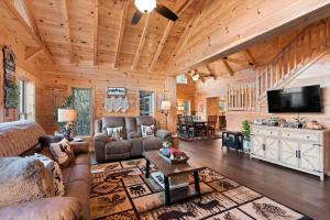 a living room with couches and a flat screen tv at Woodlake Log Cabin in Elk Park