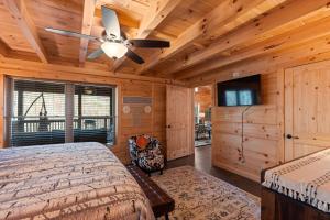 a bedroom with a bed and a ceiling fan at Woodlake Log Cabin in Elk Park