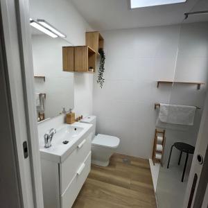 biała łazienka z toaletą i umywalką w obiekcie Holiday Studio by Meatina w mieście Torremolinos