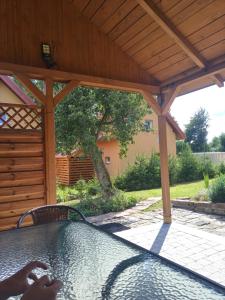 a person is sitting at a table under a pergola at Gajówka in Radków