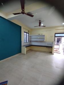 una stanza vuota con un ventilatore a soffitto e una grande finestra di The Family Nest a Prayagraj