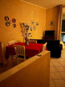 a dining room with a red table and chairs at Albenga La Romantica in Albenga