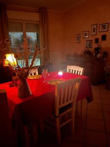 a table with a red table cloth and a candle on it at Albenga La Romantica in Albenga