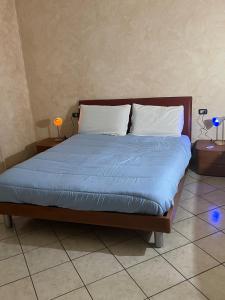a bed with blue sheets and white pillows on it at Albenga La Romantica in Albenga