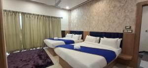 two beds in a room with blue and white at BlueNeck Ayodhya-Near ShriRam Mandir in Ayodhya