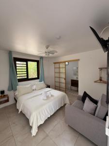 a bedroom with a large bed and a couch at MOOREA CHILL and BEACH LODGE in Teavaro