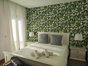 een slaapkamer met een wit bed met twee handdoeken erop bij The Old Town House by Freetimealgarve in Faro
