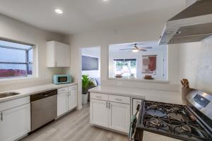 eine Küche mit weißen Schränken und einem Herd mit Backofen in der Unterkunft Urban Spanish Bungalow in San Diego