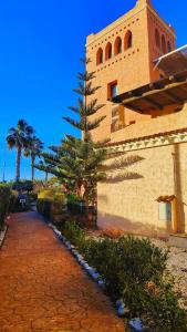 a building with a pine tree next to a sidewalk at Apartamento ideal a un paso de la playa in Playas de Vera