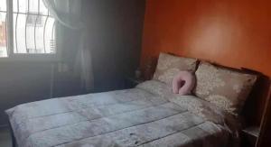 a bedroom with a bed with a pink pillow on it at appartement meuble in Tangier
