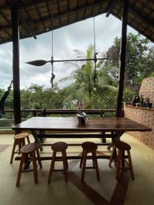 a large wooden table with four chairs and a large window at Casa do Noé in Paraty