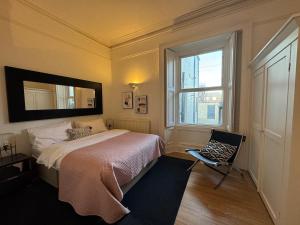 タインマスにあるLongsands House, Tynemouth Victorian Residenceのベッドと椅子と窓のある寝室