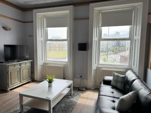 タインマスにあるLongsands House, Tynemouth Victorian Residenceのソファと2つの窓があるリビングルーム