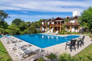 an image of a house with a swimming pool at Posada Shemak in Villa General Belgrano