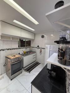 a kitchen with a stove top oven in a room at Aconchego em Campo Grande - Guaratiba in Rio de Janeiro