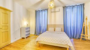 una camera con letto e tende blu di Suite Pascal by Monarca Business and Holidays - Bastia a Bastia