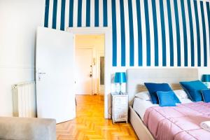 a bedroom with two beds and a striped wall at Boutique Trastevere Rome apartment Ripa 12 in Rome