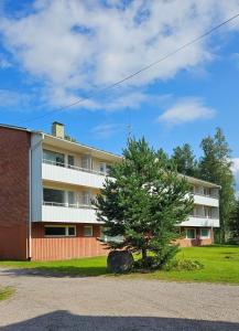 an apartment building with a tree in front of it at Himoksesta 30km, Halli, asunto 2-3hlöä,B12 in Jämsä