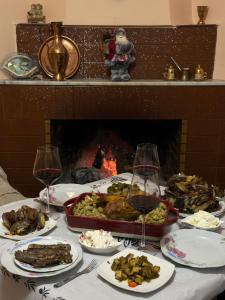 a table topped with plates of food and glasses of wine at Bujtina Polimen in Përmet