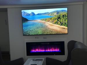 a flat screen tv hanging on a wall above a fireplace at Pvt Studio Near Waterloo Airport & Minutes to Downtown in Kitchener