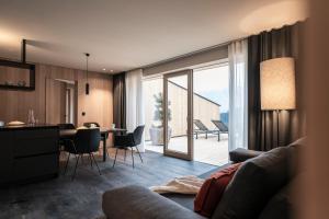 a living room with a couch and a table with chairs at apartments arduus - high living in Naturno