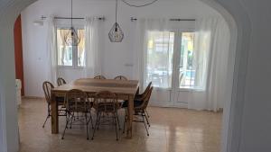 a dining room with a wooden table and chairs at Villa Carolina in Jávea