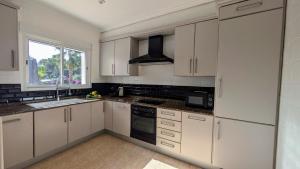 a kitchen with white cabinets and a sink and a window at Villa Carolina in Jávea +19 photos