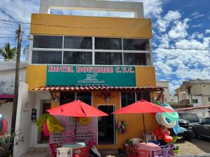 ein Restaurant mit roten Sonnenschirmen vor einem Gebäude in der Unterkunft Hotel Boutique CVC in Acapulco