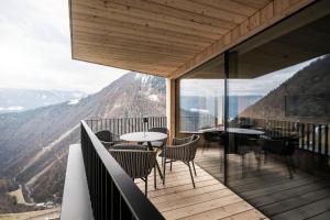 a balcony with tables and chairs on top of a mountain at apartments arduus - high living in Naturno
