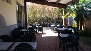 - une rangée de tables et de chaises sur la terrasse dans l'établissement Residenza S.Event B&B, à Buccinasco