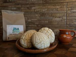three breads in a bowl on a table with a bag at Rancho San Miguel in Villa del Carbón +41 photos