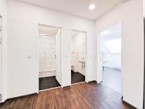 an empty bathroom with white walls and wood floors at Tolstov Apartments - City Center Apartments with 5 Rooms - 10 Min Messe DUS in Düsseldorf
