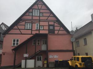 ein Haus mit einem gelben Truck, der davor parkt in der Unterkunft Kulisse Apartments in Günzburg