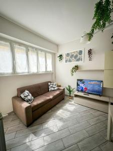 a living room with a couch and a flat screen tv at Home In Town - Fiera Milano City near San Siro Stadium metropolitana M1 - M5 in Milan