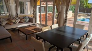 a dining room with a table and chairs and a pool at Villa Carolina in Jávea