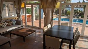 a living room with a table and a couch and a pool at Villa Carolina in Jávea