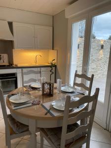 a kitchen with a table with chairs and a table and a table at Blue Cottage - Charme & Verdure in Saint-Martin-lez-Tatinghem