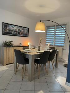 a dining room with a table with chairs and a lamp at Blue Cottage - Charme & Verdure in Saint-Martin-lez-Tatinghem
