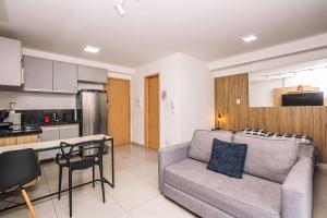 a living room with a couch and a kitchen at Deluxe Independência 915 Central Piscina/Academia in Juiz de Fora