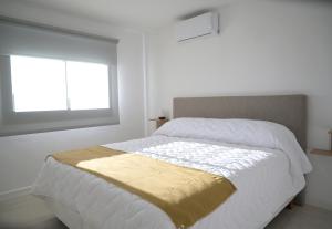 a white bedroom with a large bed with a window at Villa Artalaz in Colón +45 photos