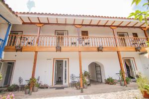 a building with a balcony and tables and chairs at QOSQO BELVEDERE, apartamento en Cuesta San Blas in Cusco
