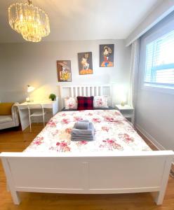 una camera con un letto bianco e un copriletto floreale. di Sunny House - Main Floor, Free parking, in Toronto a Toronto