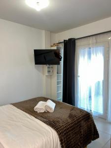a bedroom with a bed with two towels on it at Studio neuf avec acces piscine in Valergues