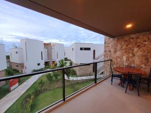 a balcony with a table and a stone wall at Loft Charmoso com Rooftop no Vila das Dunas in Flecheiras