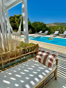 a bench with a pillow sitting next to a swimming pool at Herdade d' Amoreira Lavanda Villa in Aljezur