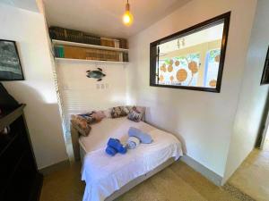 a small bed in a room with a window at Casa Chalé dos Pássaros Guarajuba in Camacari