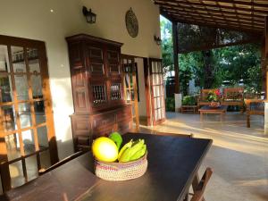 a bowl of fruit on a table in a room at Casa Chalé dos Pássaros Guarajuba in Camacari